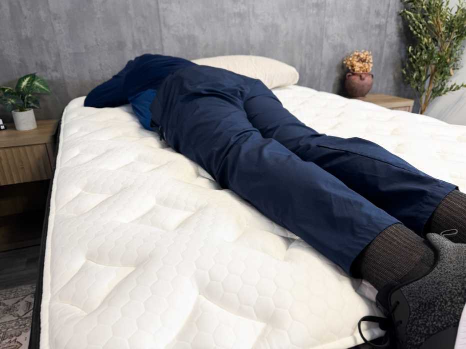 Man lying on his stomach near the center of a mattress