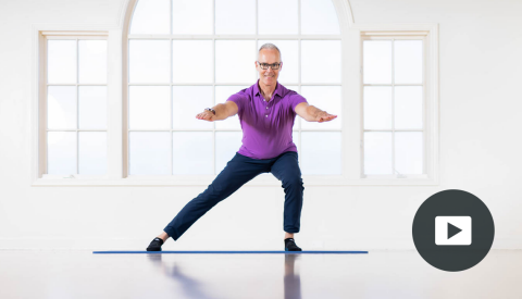 tom mccook standing on mat with arms straight out in front, left leg bent, right leg straight out to side touching mat; picture of play button on bottom right corner
