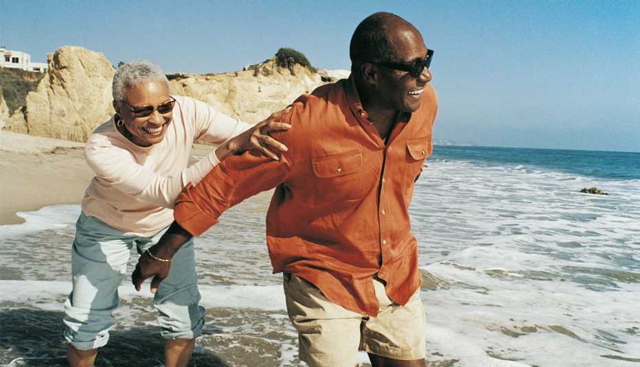 a couple frolic on a beach together