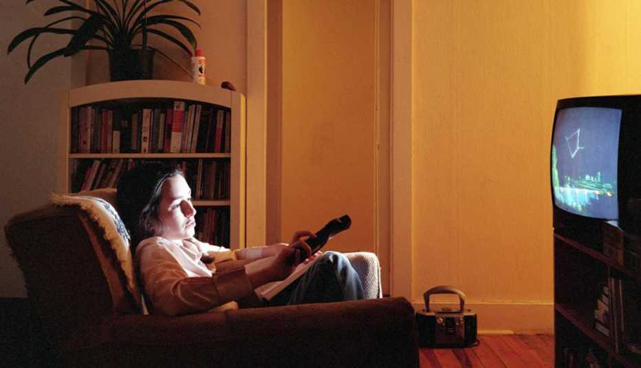 Young woman using television with a remote control, Coach Potato Syndrome, Healthy Living