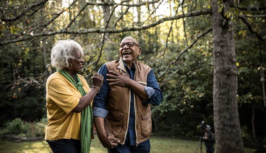 man and woman walking in the woods laughing