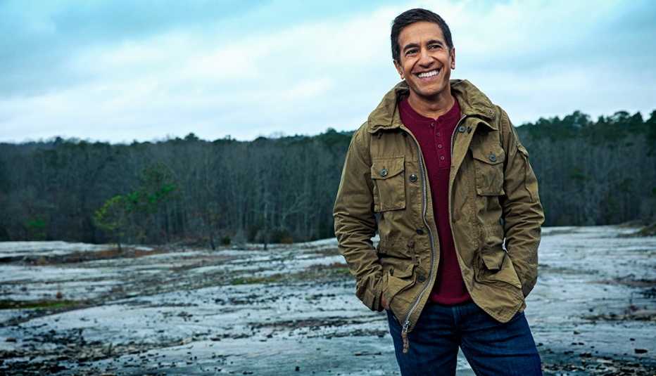doctor sanjay gupta photographed outdoors smiling on a mountain peak