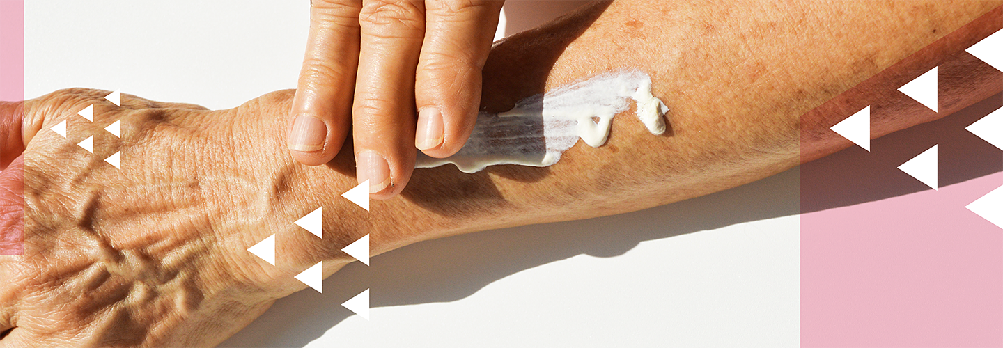 close shot of a womans arm while she rubs in a blob of lotion with her other hand