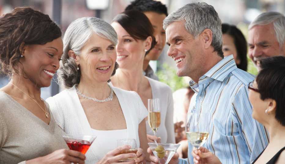 group of older adults at a cocktail party talking and holding drinks group of older adults at a cocktail party talking and holding drinks
