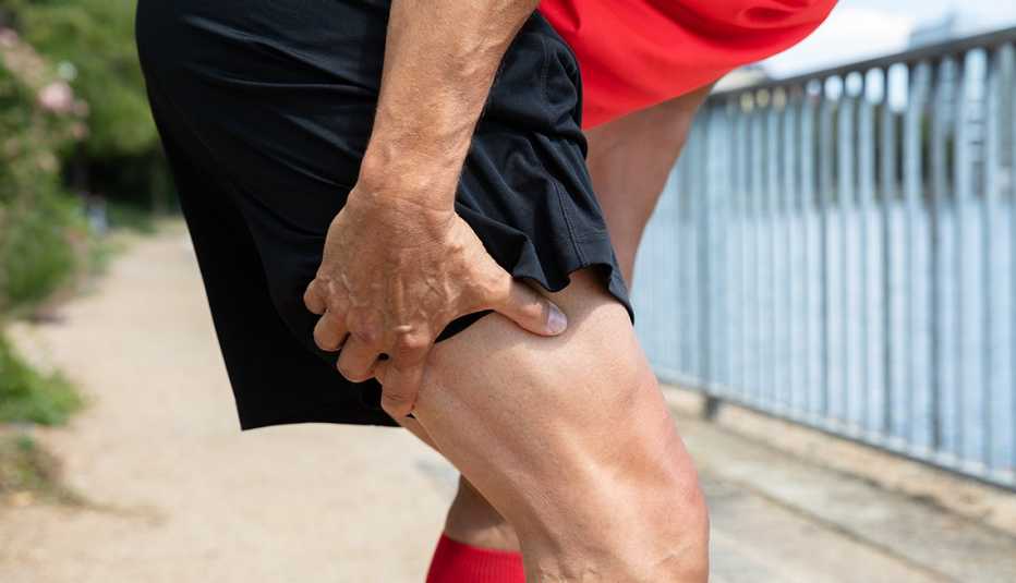 male runner holding the back of his leg in pain