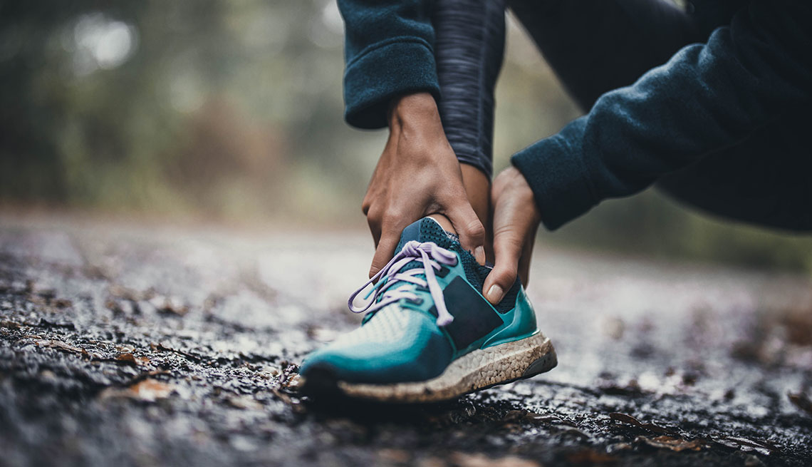woman holding injured ankle