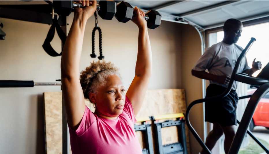 couple lifting weights and working out in their garage