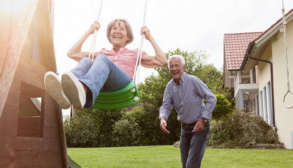 A playful couple playing with a swing in the backyard A playful couple playing with a swing in the backyard