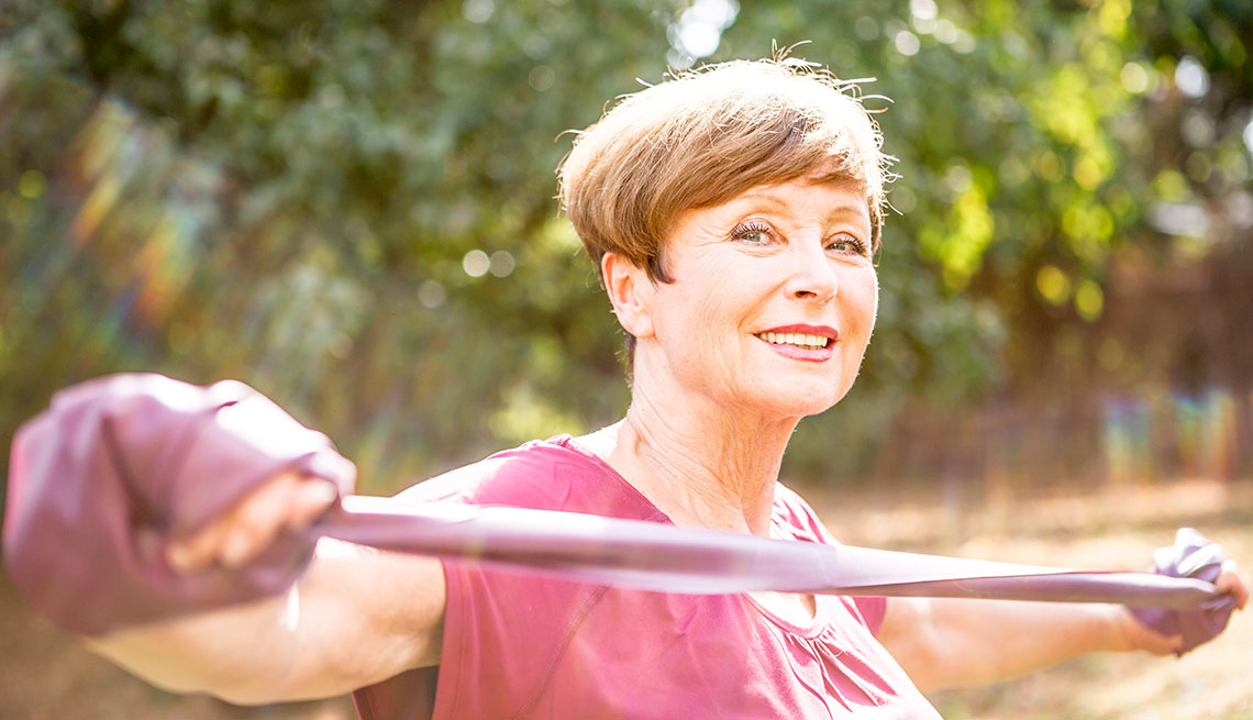 A woman stretches an exercise band
