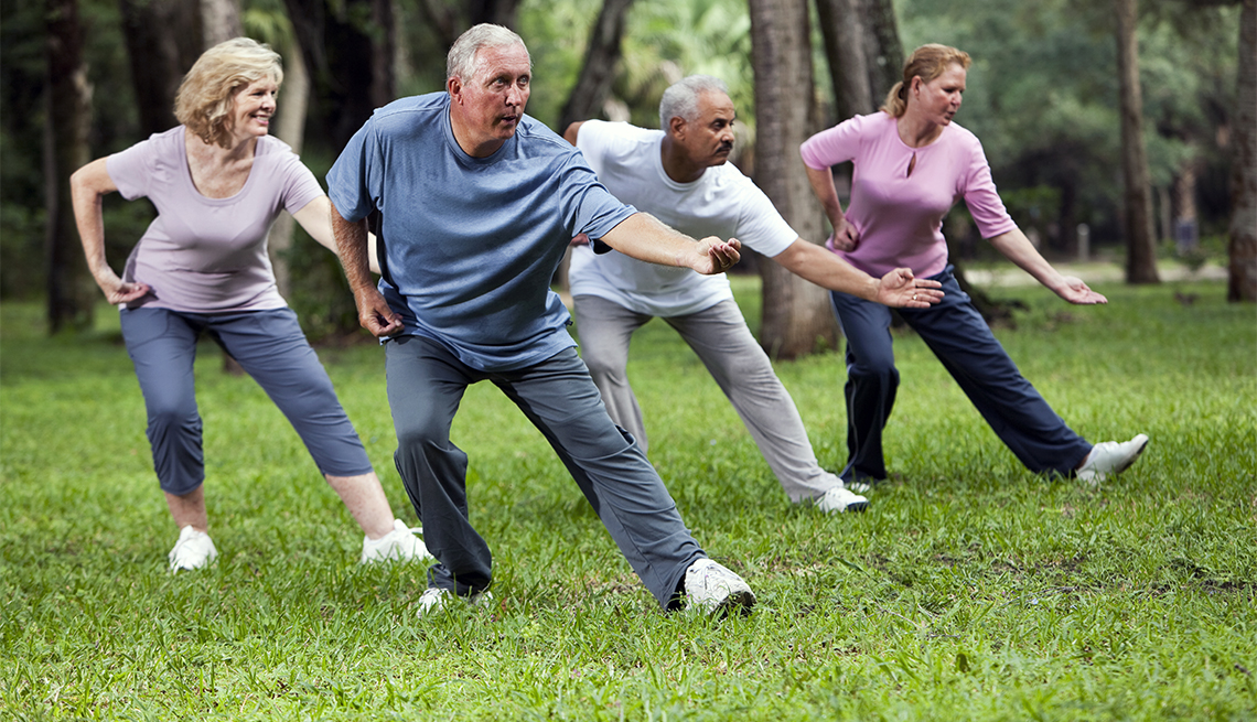 Older adults in a woodland practicing Tai Chi. Increasing proprioception is a great way to help prevent falls.