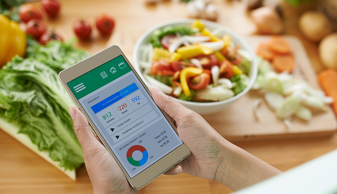 A woman using a calorie counter app on her smartphone