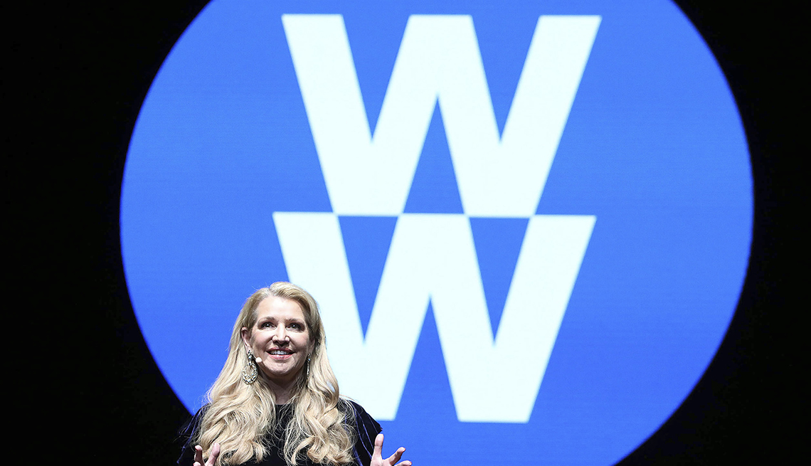 Weight Watchers CEO next to Weight Watchers new logo