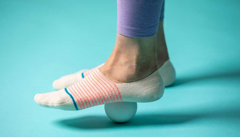 closeup of a foot on top of a ball rolling on the ground