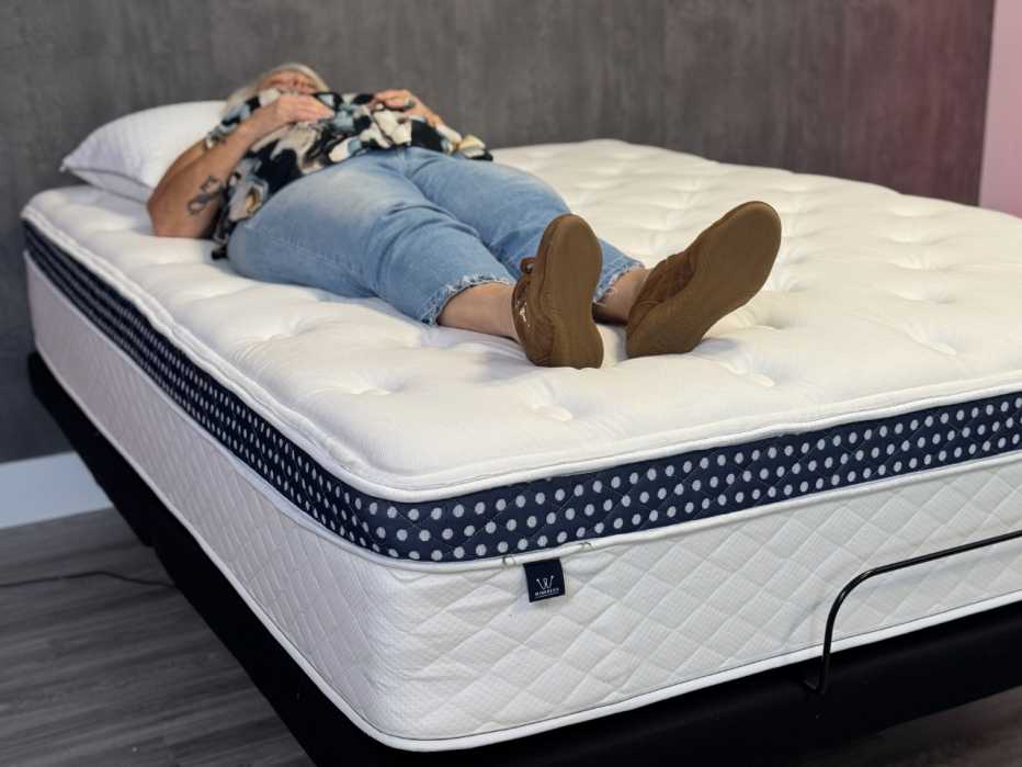 A woman lying on her back on the WinkBed mattress.