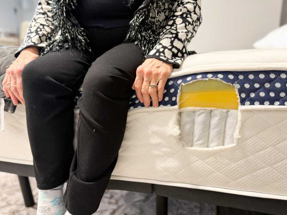Woman sitting on the edge of the WinkBed Plus mattress.
