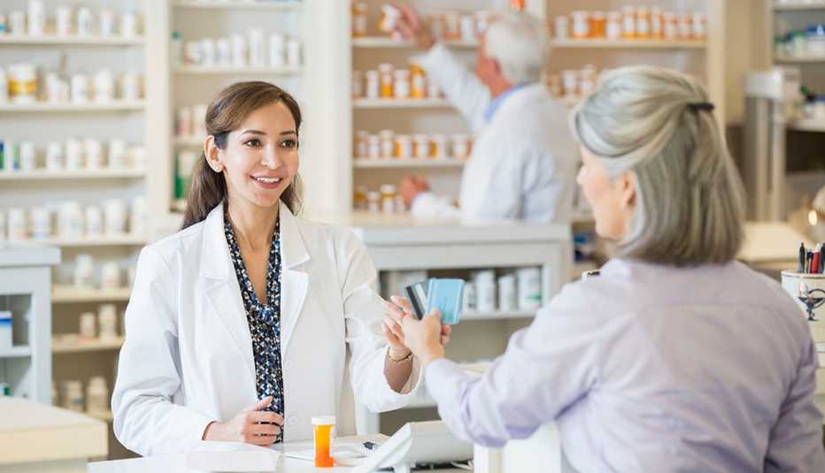 Customer paying pharmacist.