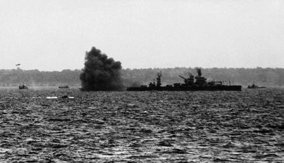 WWII France D-Day a puff of black smoke blows away from the guns of the battleship u s s arkansas