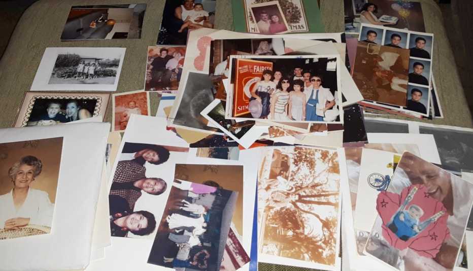 dozens of old family photos school photos and portraits are spread out on top of a bed