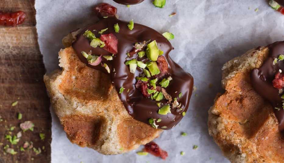 closeup of a gluten free waffle cookie topped with dark chocolate and chopped pistachio nuts