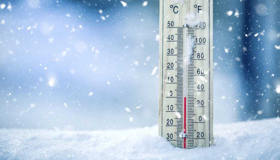 Thermometer on snow shows low temperatures - zero. Low temperatures in degrees Celsius and fahrenheit. Cold winter weather - zero celsius thirty two farenheit.
