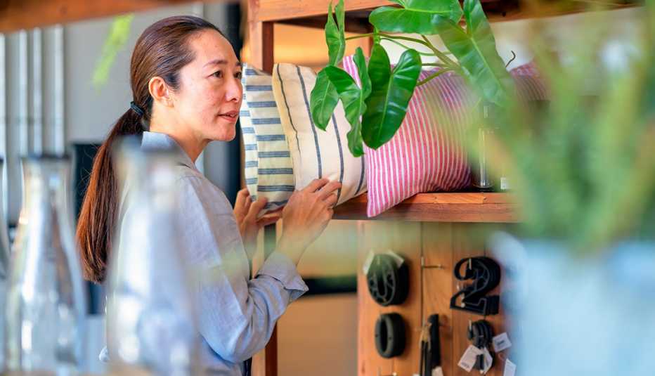 a woman in a store looking at pillows