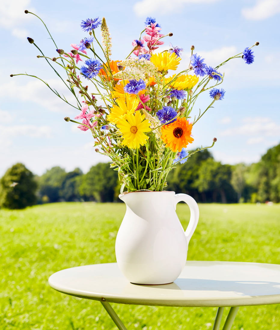 a vase of flowers on a table outside