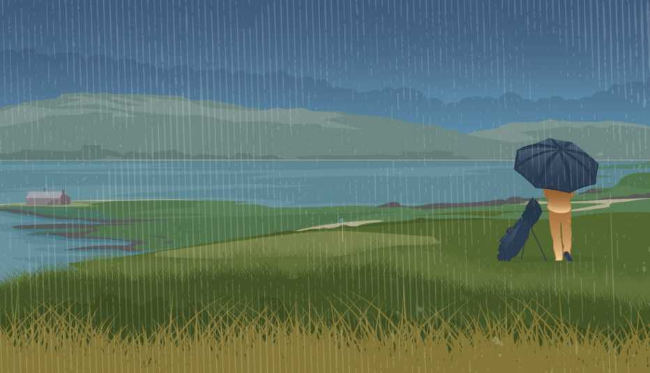 A lone golfer stands on the green of a golf course in the rain with an umbrella and a golf bag.