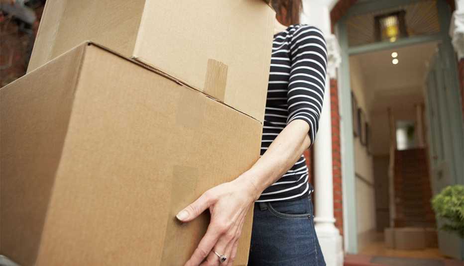 a woman carrying cardboard boxes