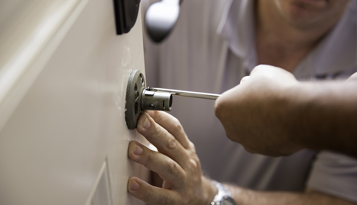 two people work together to install a new door lock
