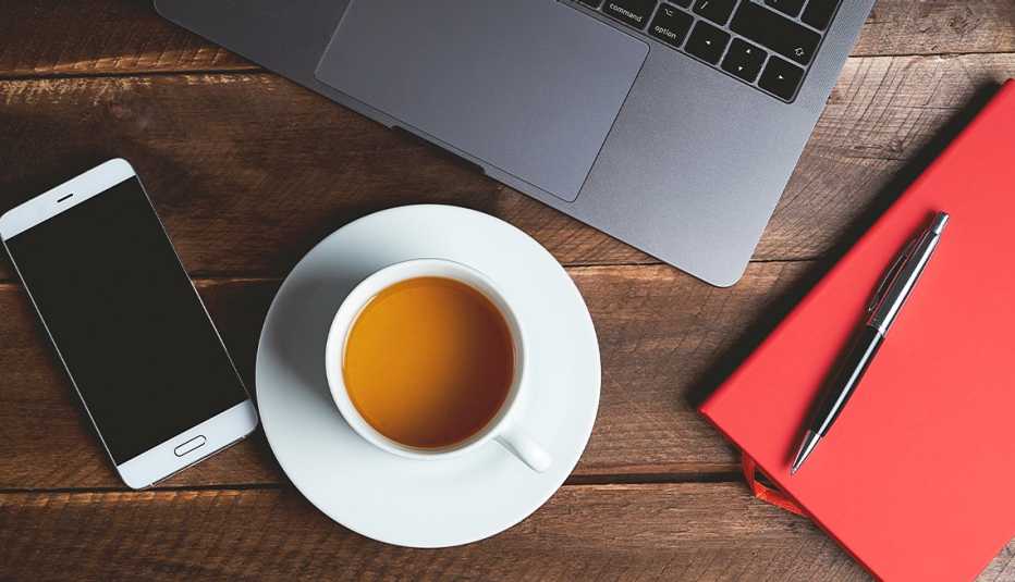 Cell phone, cup of coffee, book, pen, laptop on table cell phone, cup of coffee, book, pen, laptop on table