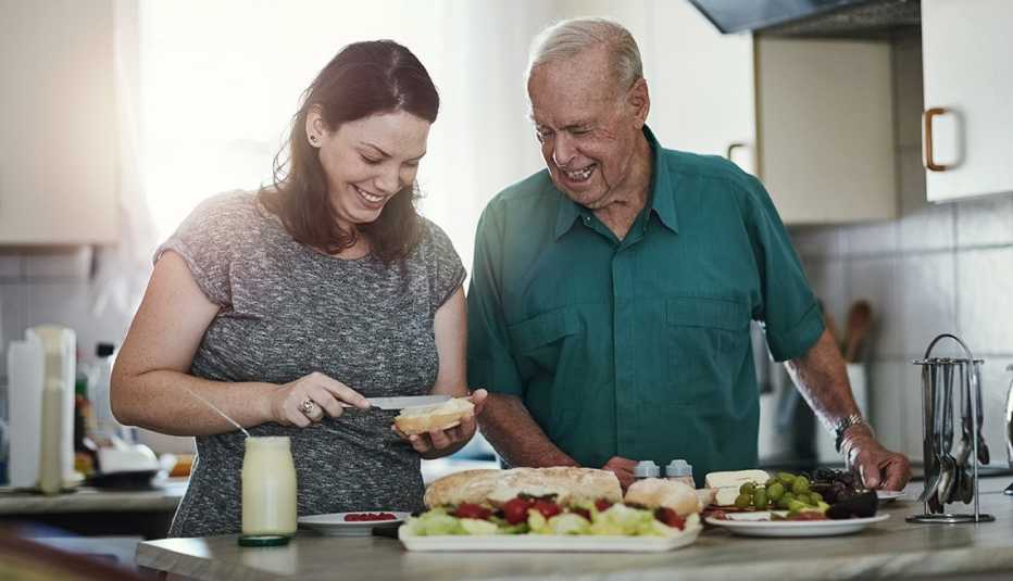 Shot of a woman making her senior parent a sandwich