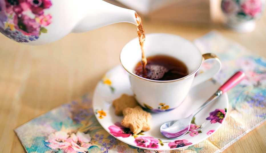 a cup of tea poured into a flowered tea cup