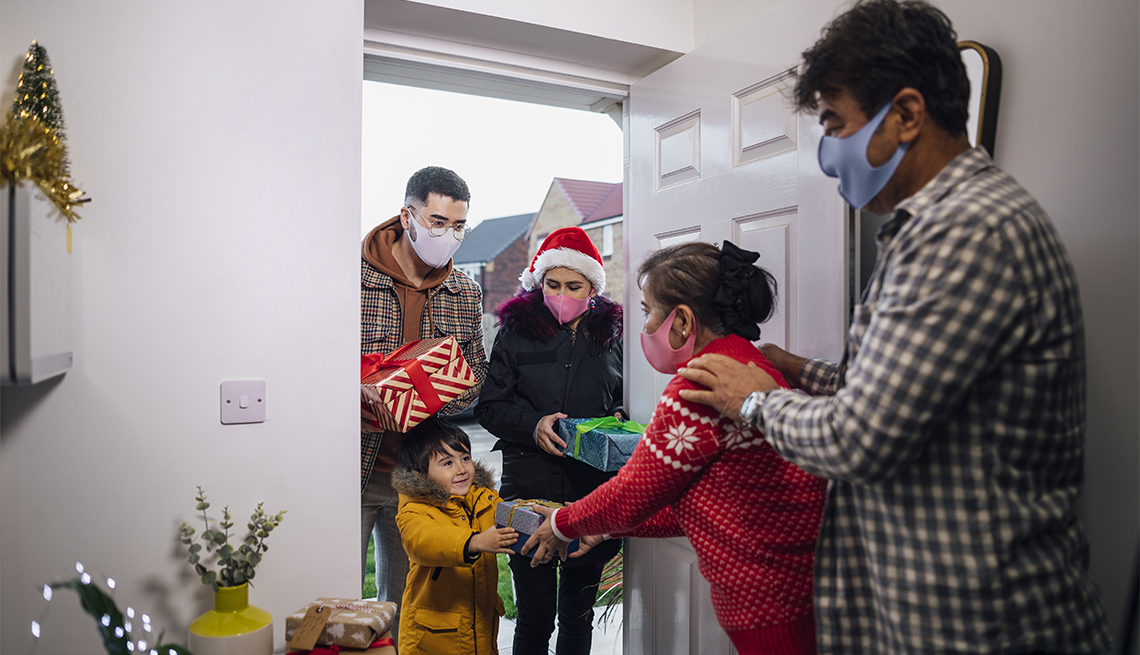 couple standing at their front door with their grandson and family 
