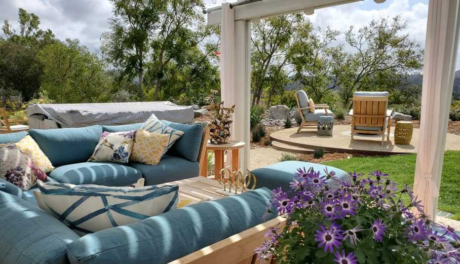 an outdoor covered patio with seating and curtains
