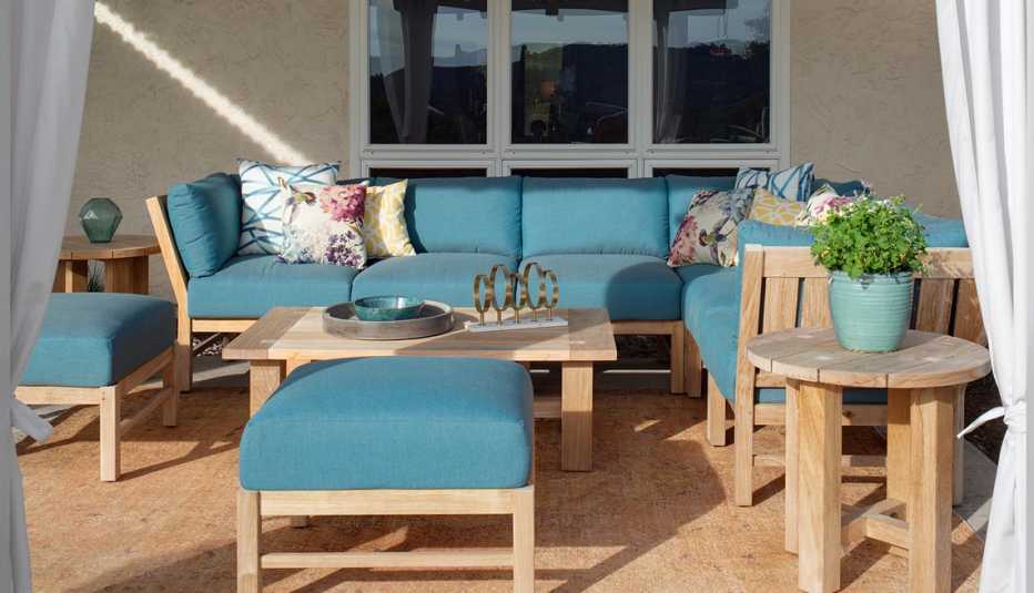 a sunlit seating area with furniture and an outdoor rug on a patio
