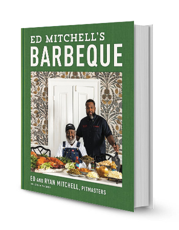 ed and ryan mitchell behind table with a bunch of food on book cover that says ed mitchell's barbecue; ed and ryan mitchell, pitmasters with zella palmer ed and ryan mitchell behind table with a bunch of food on book cover that says ed mitchell's barbecue; ed and ryan mitchell, pitmasters with zella palmer