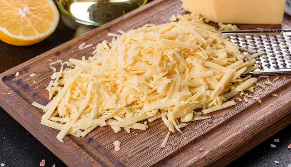 Fresh hard cheese grated on a large grater 