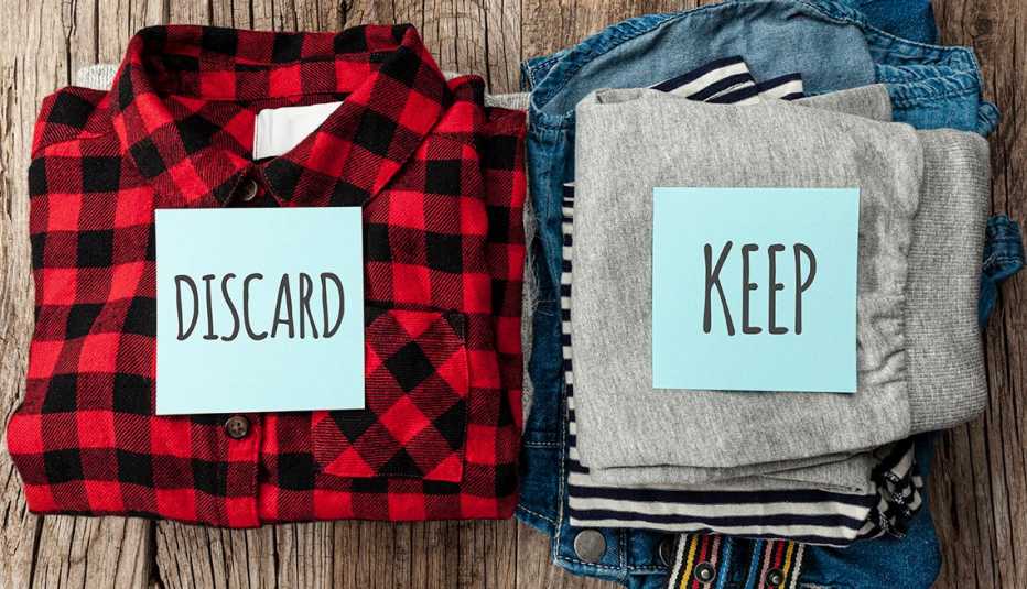Stack of old clothes to discard (declutter) or keep. Recycle clothes, eco cotton.