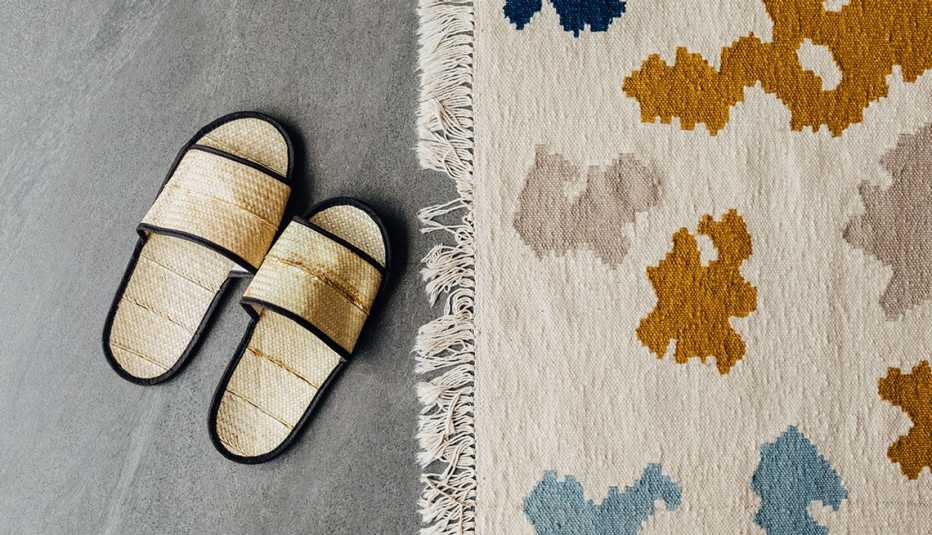 pair of slippers next to an area rug