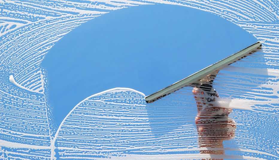 hand washing window with squeegee; soap on window hand washing window with squeegee; soap on window