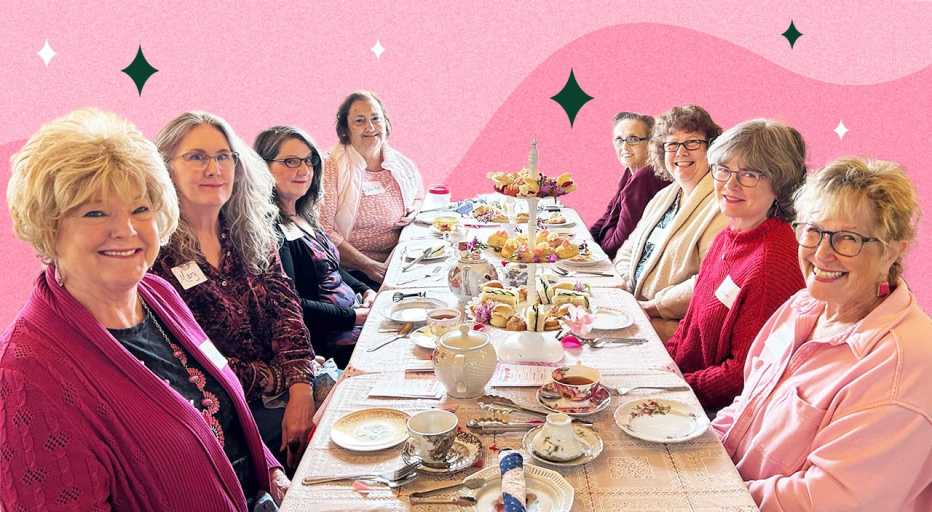 Women sitting at a table on a pink background