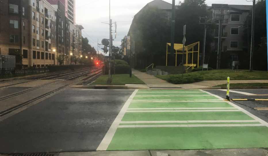A wide, green-painted crosswalk near the light rail in Charlotte, North Carolina