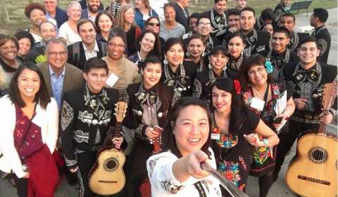 Attendees at the 2017 AARP Livable Communities pose with a mariachi band in the Trinity Groves area of Dallas, Texas