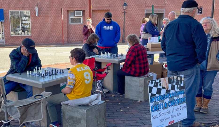 Children and adults play chess on outdoor tables Children and adults play chess on outdoor tables
