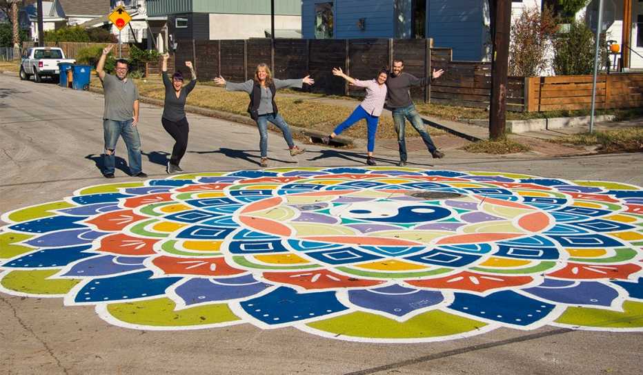 Five volunteers celebrate the completion of a street mural
