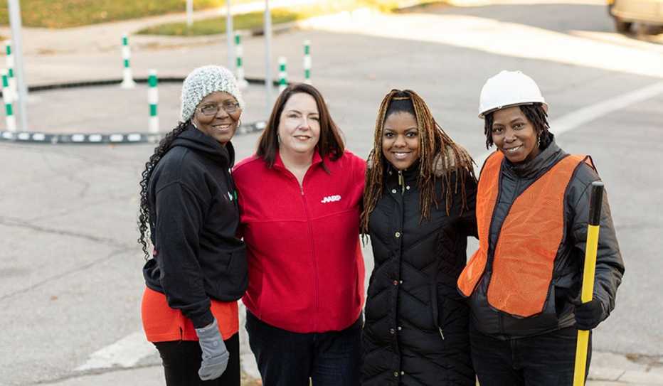 Four people pose for a photo in front of a new traffic circle
