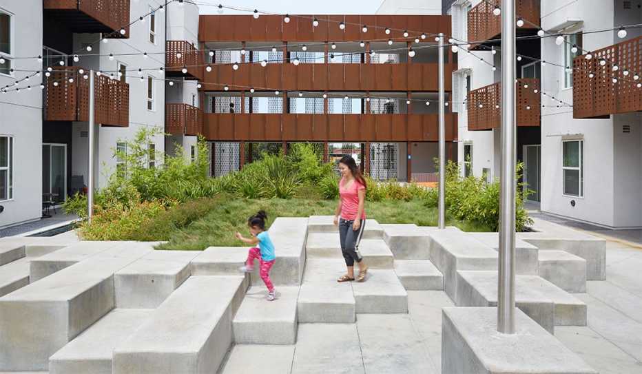 A mother and child walk through a courtyard at the Rivermark housing complex.