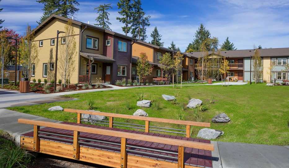 A view of a footbridge and townhomes in the Bridge Meadows housing community
