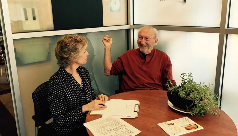 Elderly Man Sitting At Table With Woman Looking Over Papers, Aging Well Resource Center, Livable Communities