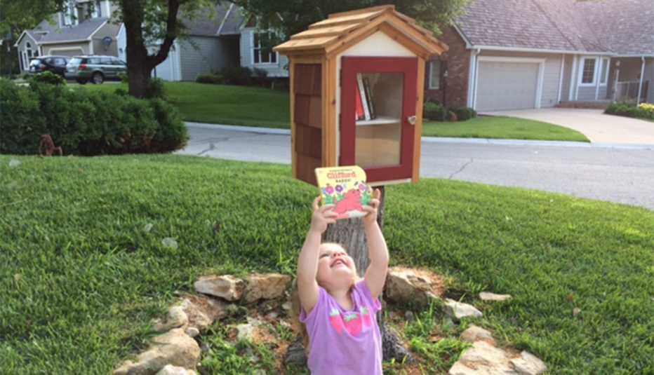A preschool-age girl holds a book about Clifford the Big Red Dog.
